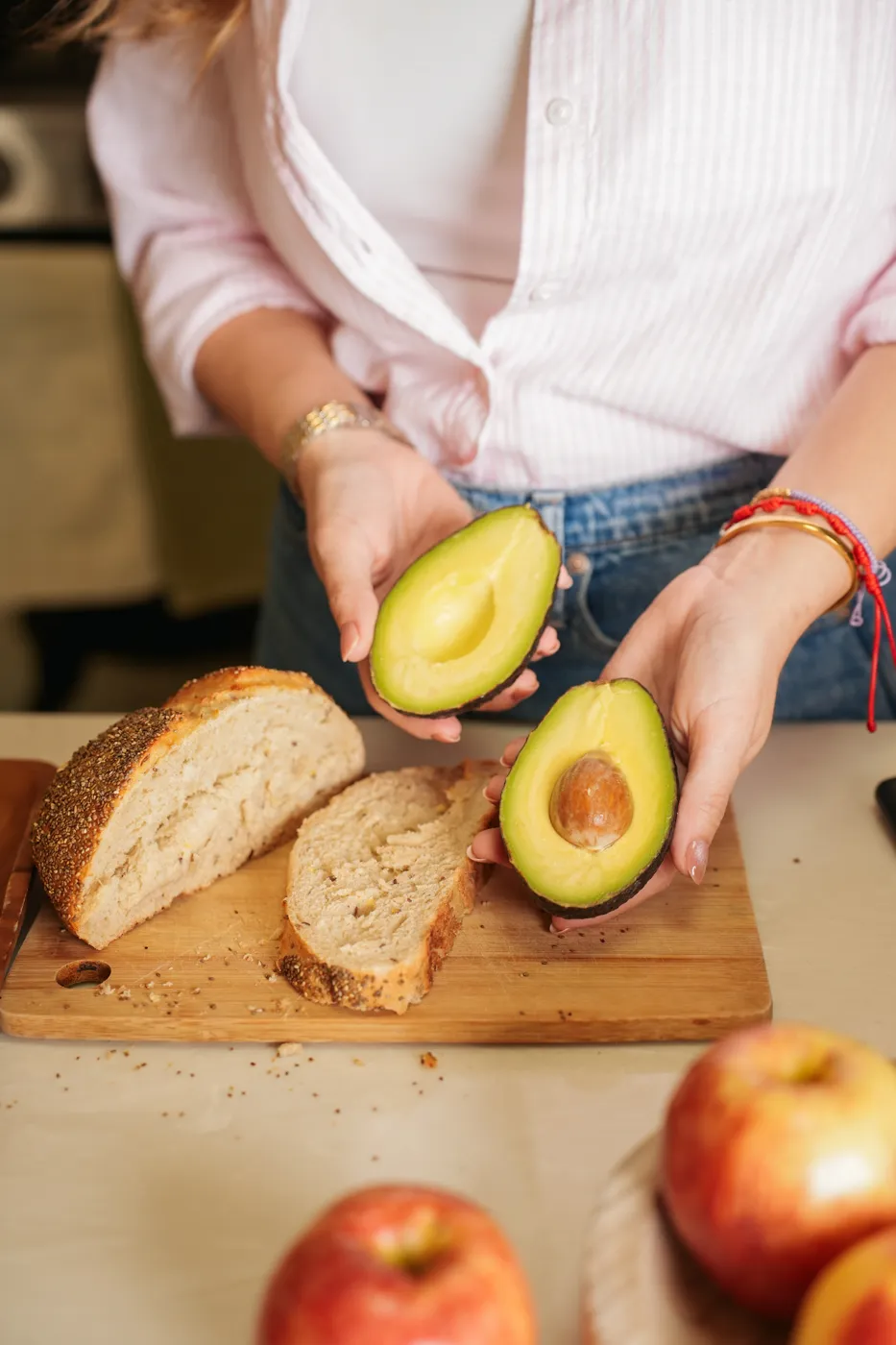 Manos preparando aguacate y pan integral